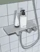 Ablage in Chrom mit Badethermostat, zwei Reglern und flexibler Brauseschlauchmontage, montiert an weißen Fliesen. Ideal Standard Produkt.
